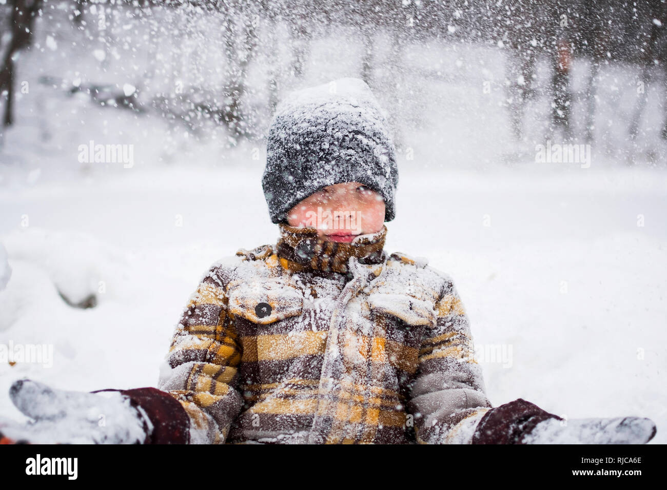Garçon debout dans une tempête de neige, attraper des flocons, Wisconsin, United States Banque D'Images
