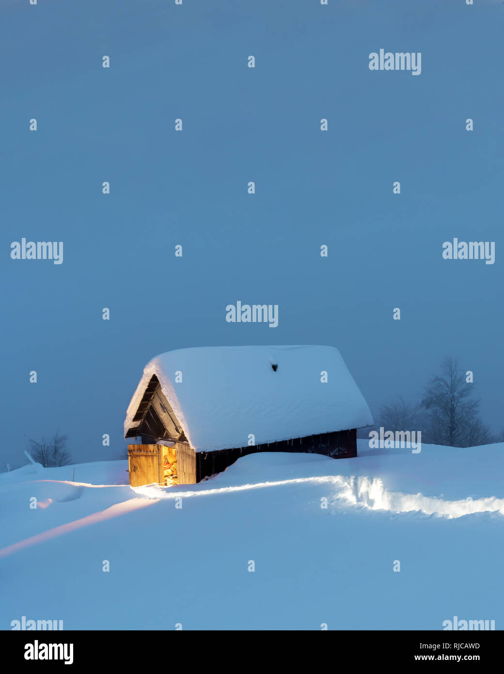 Paysage d'hiver fantastique avec maison en bois dans les montagnes enneigées. Concept de vacances de Noël Banque D'Images