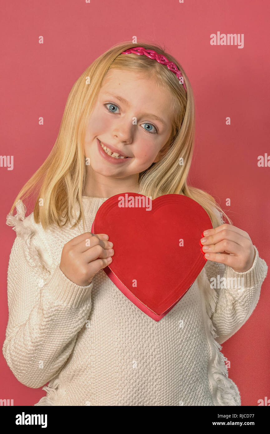 Adorable fille d'âge scolaire avec boîte coeur de la Saint-Valentin le chocolat Banque D'Images
