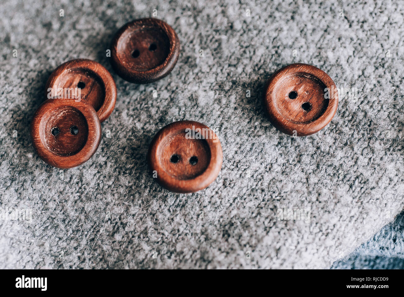 Boutons en bois qui sont placés aléatoirement sur un fond gris Banque D'Images