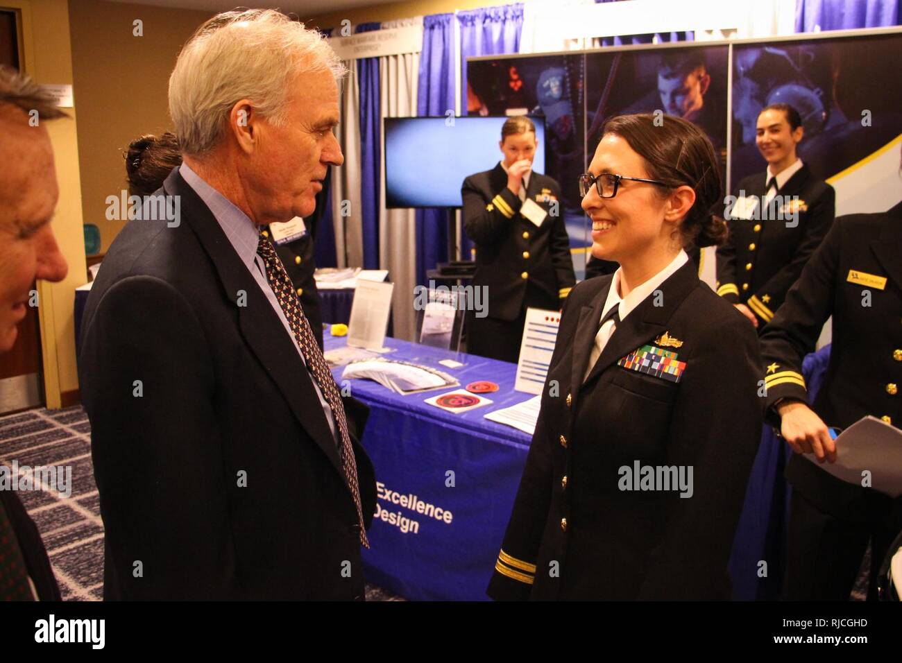 CRYSTAL CITY, en Virginie (janv. 11, 2018) Secrétaire de la Marine Richard C. Spencer, gauche, parle avec le Lieutenant Rachel Messina, un instructeur de tactiques de guerre (WTI) affectés à la défense antimissile et de l'air intégrés de la Division de la surface de combat naval et Centre de développement de la mine (SMWDC), à la 30e assemblée annuelle de l'Association marine de surface (SNA) Symposium National. SMWDC est l'un de la marine de guerre de cinq centres de développement et sa mission est d'accroître la létalité et la performance tactique de la surface de travail dans tous les domaines. Banque D'Images