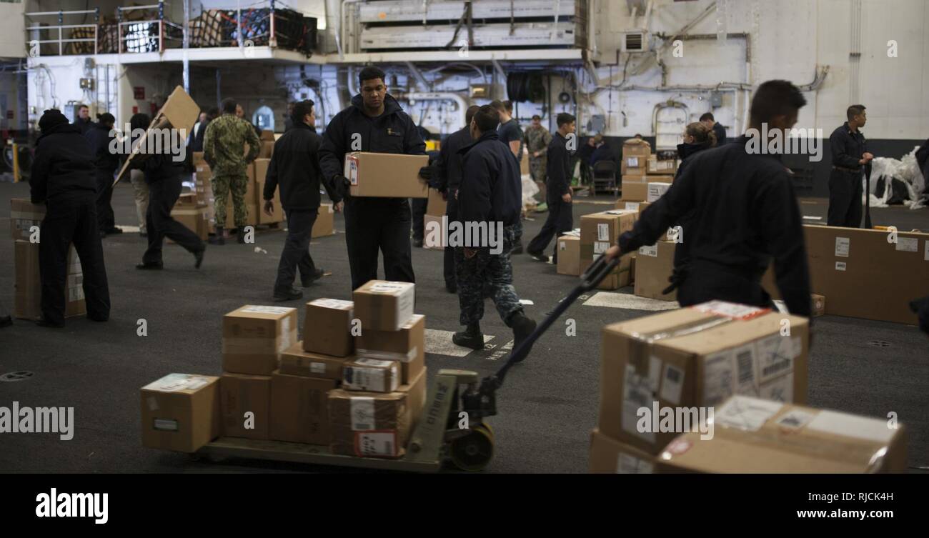 Océan Pacifique (jan. 12, 2018) marins fournitures trier dans le hangar de la baie d'assaut amphibie USS Wasp LHD (1) au cours d'un ravitaillement en mer (RAS) avec le navire de marchandises sèches et de munitions USNS Wally Schirra (T-AKE 8). Le Wasp est transitant à Sasebo, au Japon pour réaliser un chiffre d'affaires avec l'USS Bonhomme Richard (DG 6) comme l'avant-déployés navire amiral de la force amphibie dans la 7e flotte américaine zone d'opérations. Banque D'Images