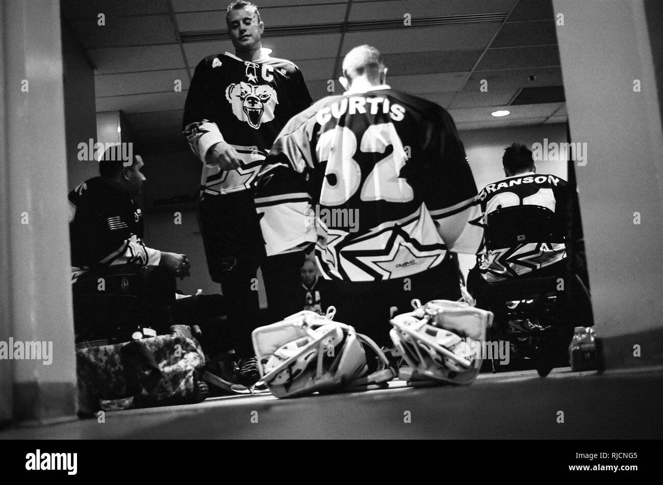 Le capitaine de l'Armée de Cody Ikkala, gauche, passe devant le capitaine de l'Armée de Scott Curtis, dans le vestiaire entre les périodes au cours de la 5e Air Force Armée vs Match de hockey, le 13 janvier, 2018, à la patinoire Sullivan à Anchorage, Alaska. Le jeu se joue chaque année entre les équipes de service membres affectés à Joint Base Elmendorf-Richardson, Alaska, favorise l'esprit de corps militaires et améliore la relation entre l'ancrage et JBER communauté. L'équipe de la Force aérienne a gagné le match 11-1. Banque D'Images