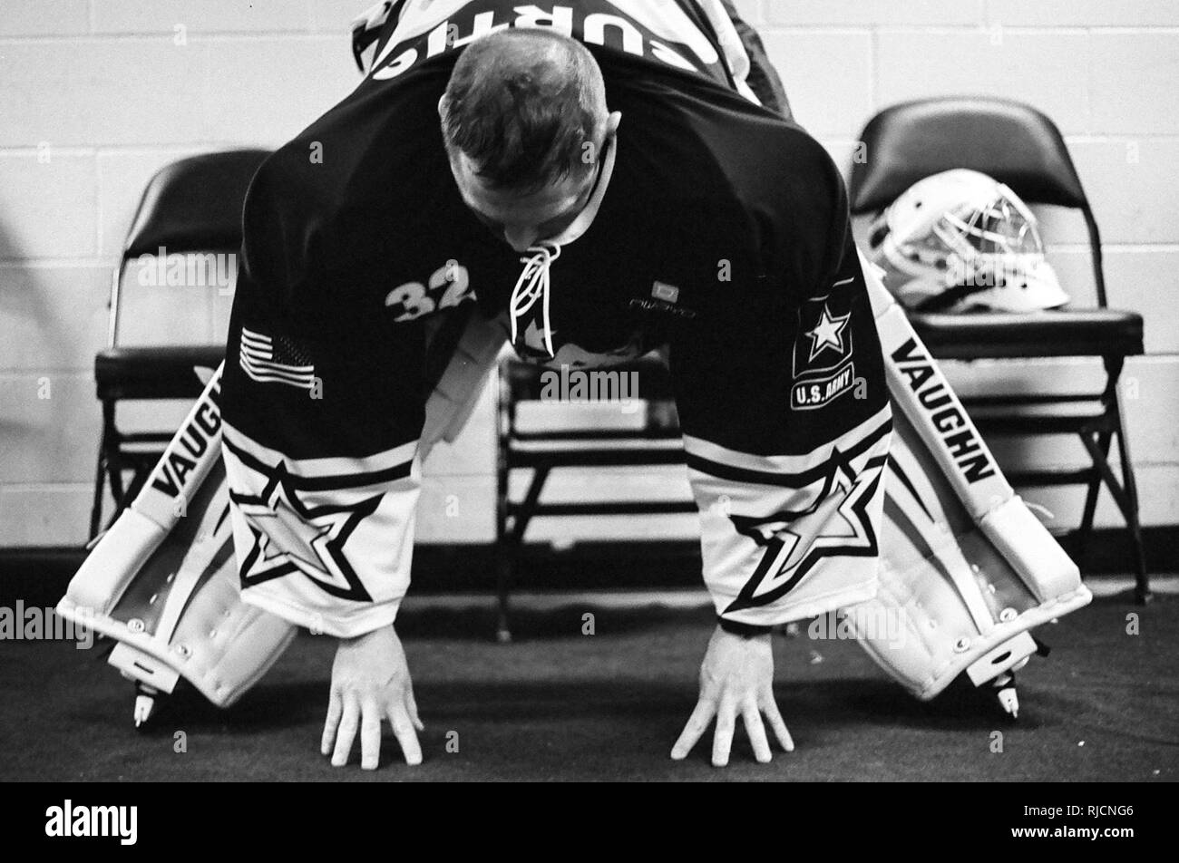 Le capitaine de l'Armée de Scott Curtis s'étend à l'extérieur de la salle de casier entre les périodes au cours de la 5e Air Force Armée vs Match de hockey, le 13 janvier, 2018, à la patinoire Sullivan à Anchorage, Alaska. Le jeu se joue chaque année entre les équipes de service membres affectés à Joint Base Elmendorf-Richardson, Alaska, favorise l'esprit de corps militaires et améliore la relation entre l'ancrage et JBER communauté. L'équipe de la Force aérienne a gagné le match 11-1. Banque D'Images