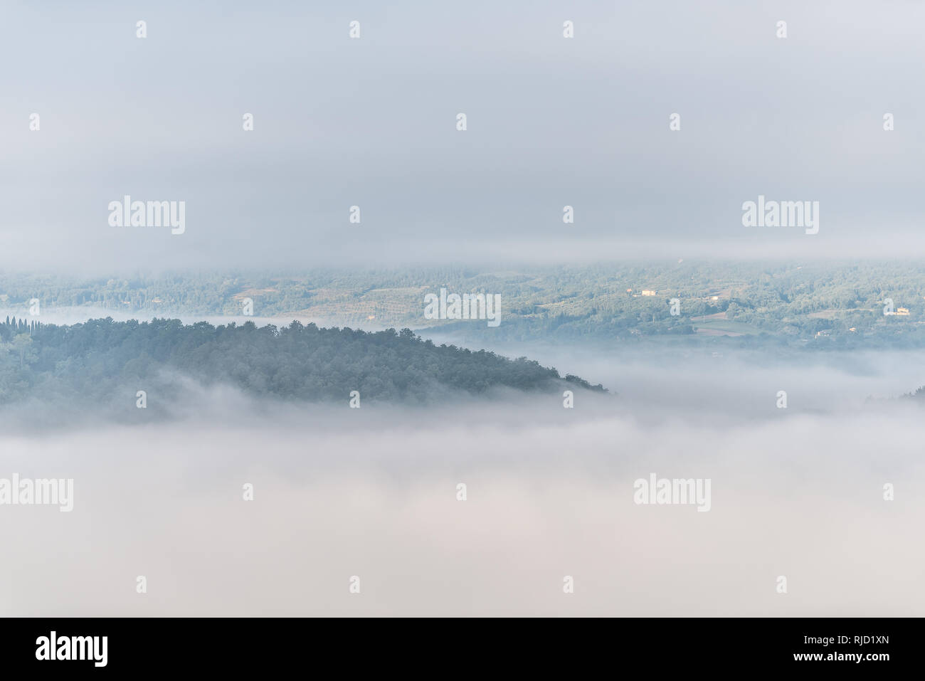 Chiusi Scalo mountain mist brouillard lever du soleil et les villas maisons en Ombrie et Toscane en Italie avec des nuages couvrant couvrant l'inversion dans l'été Banque D'Images