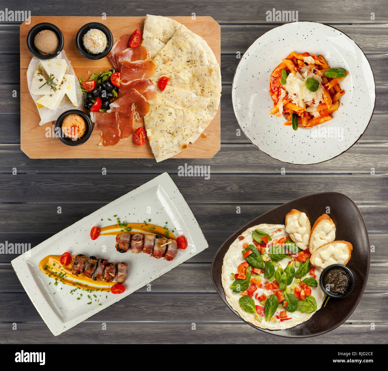 Différents aliments servis sur une table en bois, apéritif et pâtes Banque D'Images Différents aliments servis sur une table en bois, apéritif et pâtes Banque D'Images