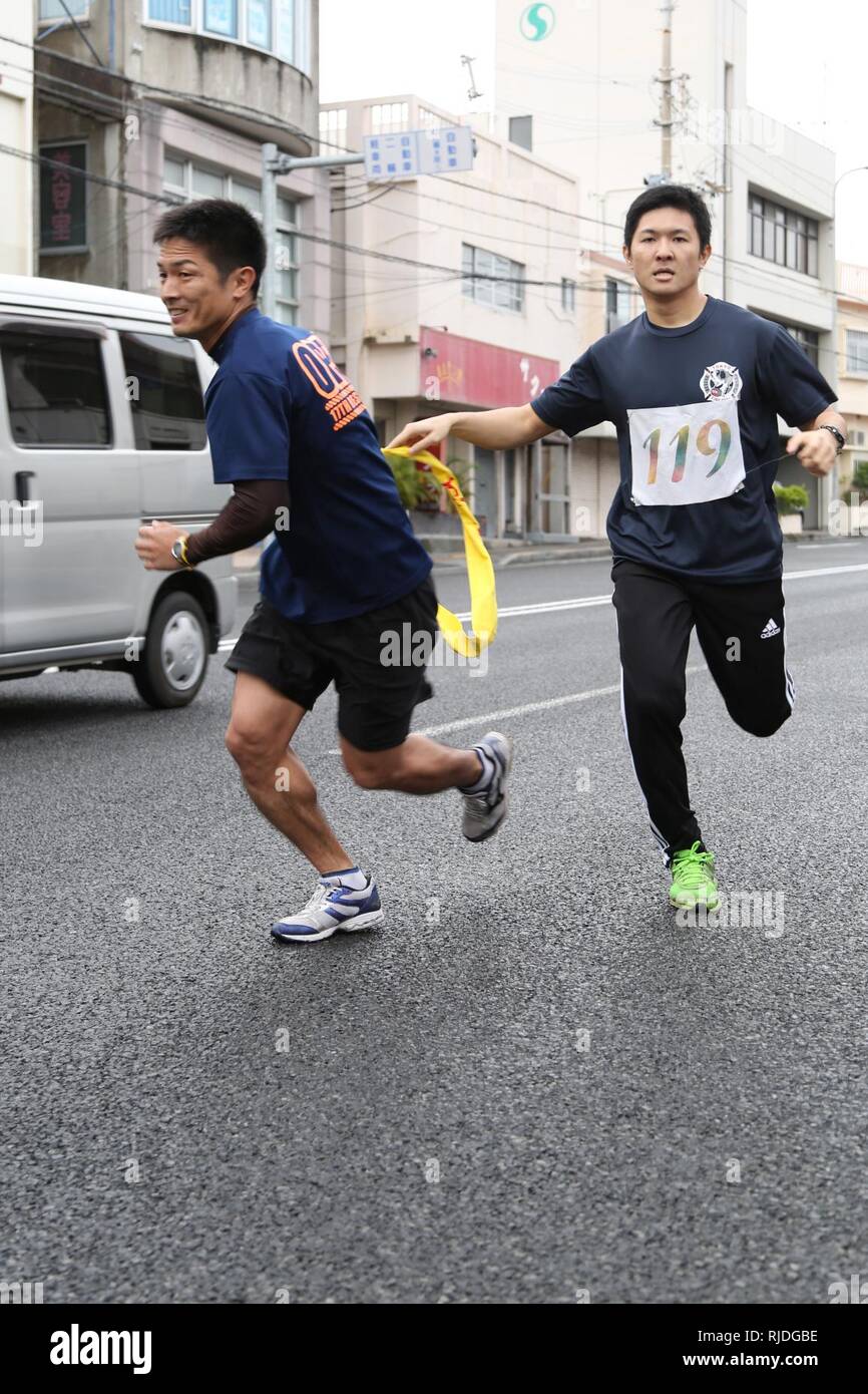 FUTENMA MARINE CORPS AIR STATION, Okinawa, Japon - Les membres de l'incendie de la ville de Ginowan main une écharpe au cours de la 41e ville Ginowan annuel Campagne de sécurité routière Road Race 20 janvier dans la ville de Ginowan, Okinawa, Japon. La course a été un moyen pour les autorités locales et de collectivités américaines pour bond par compétition amicale et apprendre l'importance de la sécurité routière. La course de relais a eu lieu sur, et autour du périmètre extérieur de Futenma Marine Corps Air Station, qui s'étend sur 13 kilomètres. Banque D'Images