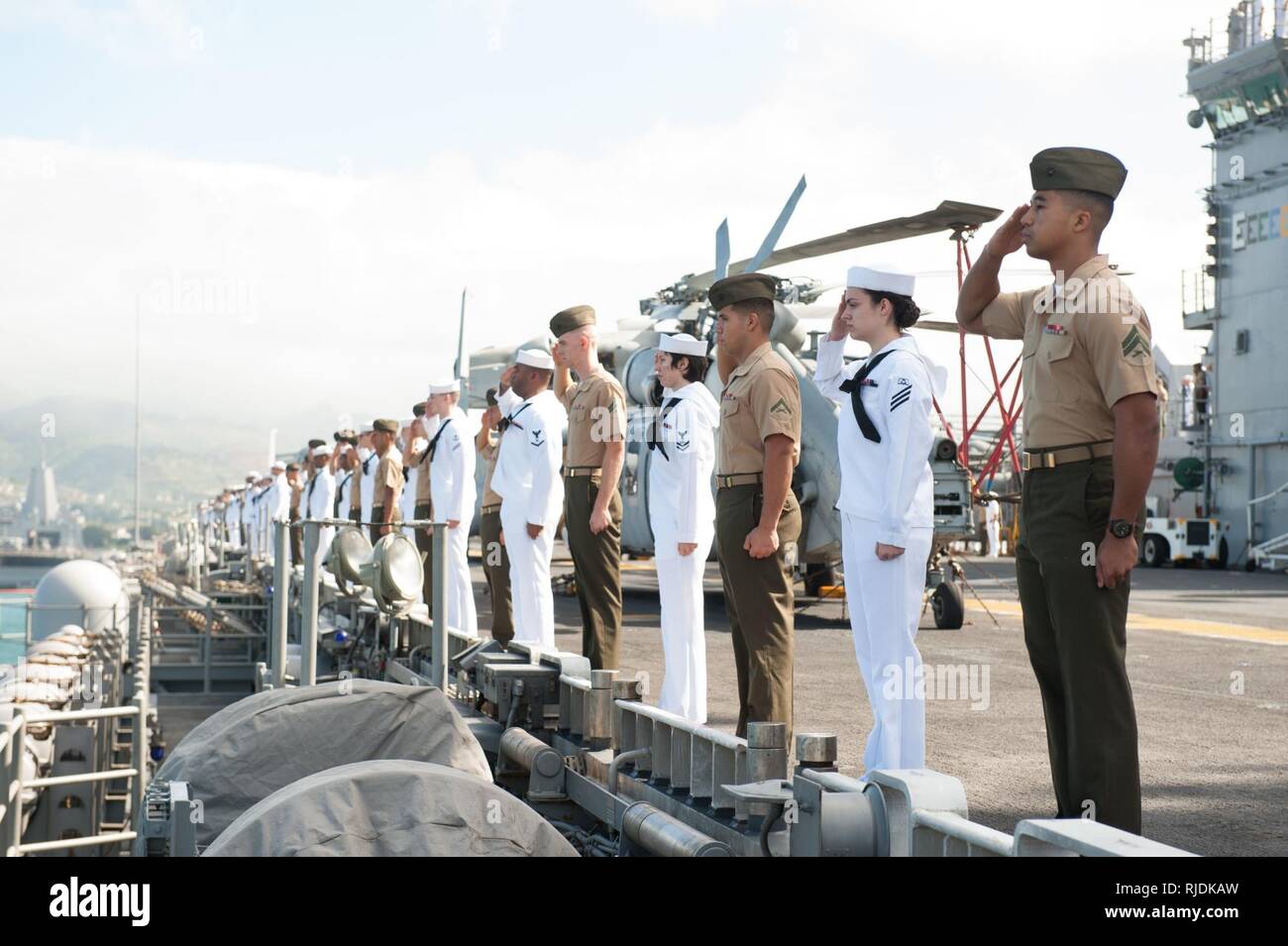 PEARL HARBOR (janv. 23, 2018) marins et marines à bord du navire d'assaut amphibie USS America (LHA 6) salue le USS Arizona Memorial à mesure que le navire arrive à Pearl Harbor pour un service au port. Amérique latine, une partie de l'Amérique du groupe amphibie, avec la 15e unité expéditionnaire de Marines embarqués (15e MEU), est de retour d'un déploiement de 7 mois aux États-Unis 3e, 5e et 7e flotte secteurs d'opérations. Banque D'Images