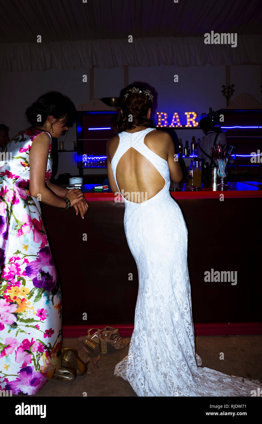 Une épouse sur sa robe de mariage et un ami sont au bar de nuit. Banque D'Images