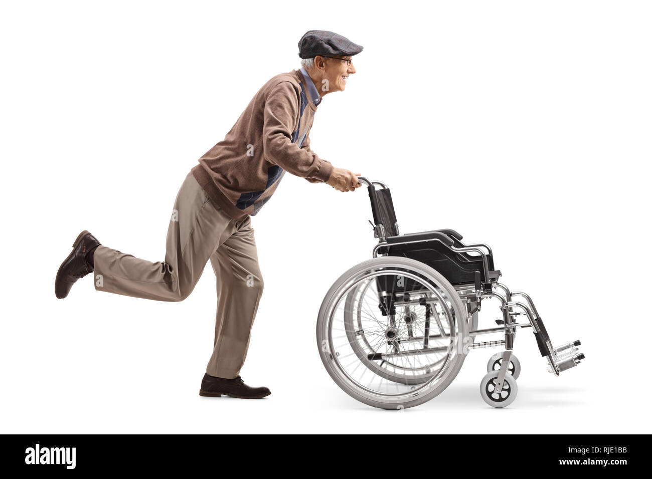 De toute la longueur, un homme âgé d'exécution et en poussant un fauteuil roulant vide isolé sur fond blanc Banque D'Images