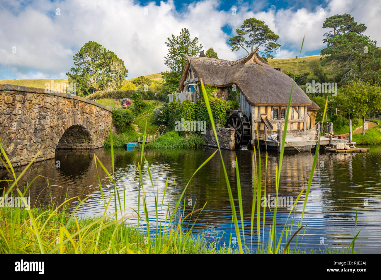 MataMata, Nouvelle-Zélande - Mars 2017 Maison de Hobbit et le vieux moulin à côté d'un vieux pont de pierre Hobbiton Banque D'Images