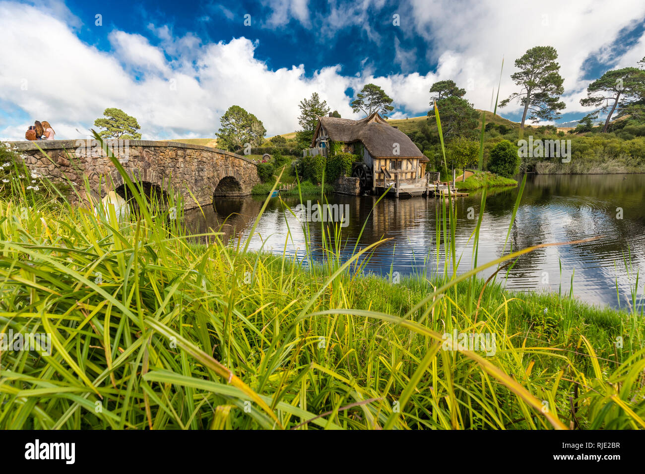 MataMata, Nouvelle-Zélande - Mars 2017 Maison de Hobbit et le vieux moulin à côté d'un vieux pont de pierre Hobbiton Banque D'Images