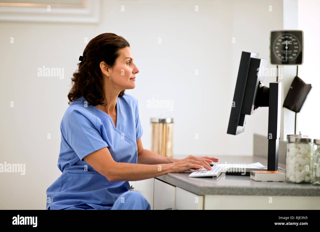 Femme médecin à l'aide d'un ordinateur à l'intérieur d'un cabinet de médecin. Banque D'Images