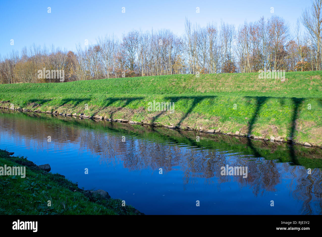 Les ombres de la fée électricité sous-station Lane towers distributions comme vu sur la rive de la rivière Mersey. L'ombre 5 pi panneaux. Banque D'Images