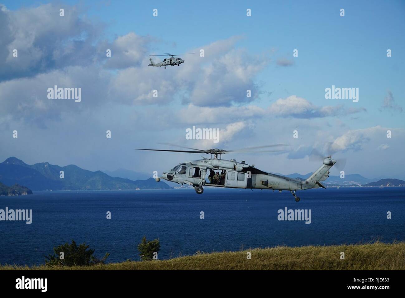 IWAKUNI, Japon (Janv. 25, 2018) La Marine américaine MH-60S Seahawk hélicoptère, affecté à l'Escadron d'hélicoptères de combat de la mer (HSC), 25 plane sur la simulation d'un navire ; tandis qu'un MH-60R Sea Hawk, affecté à l'Escadron d'hélicoptères grève maritime (HSM) 51 orbites, maintenir les frais généraux de surveillance. Ensemble, les escadrons ont effectué une visite simulé d'un hélicoptère de recherche et de saisie d'un événement au cours de deux semaines de formation de détachement expéditionnaire de Marine Corps Air Station Iwakuni. Banque D'Images