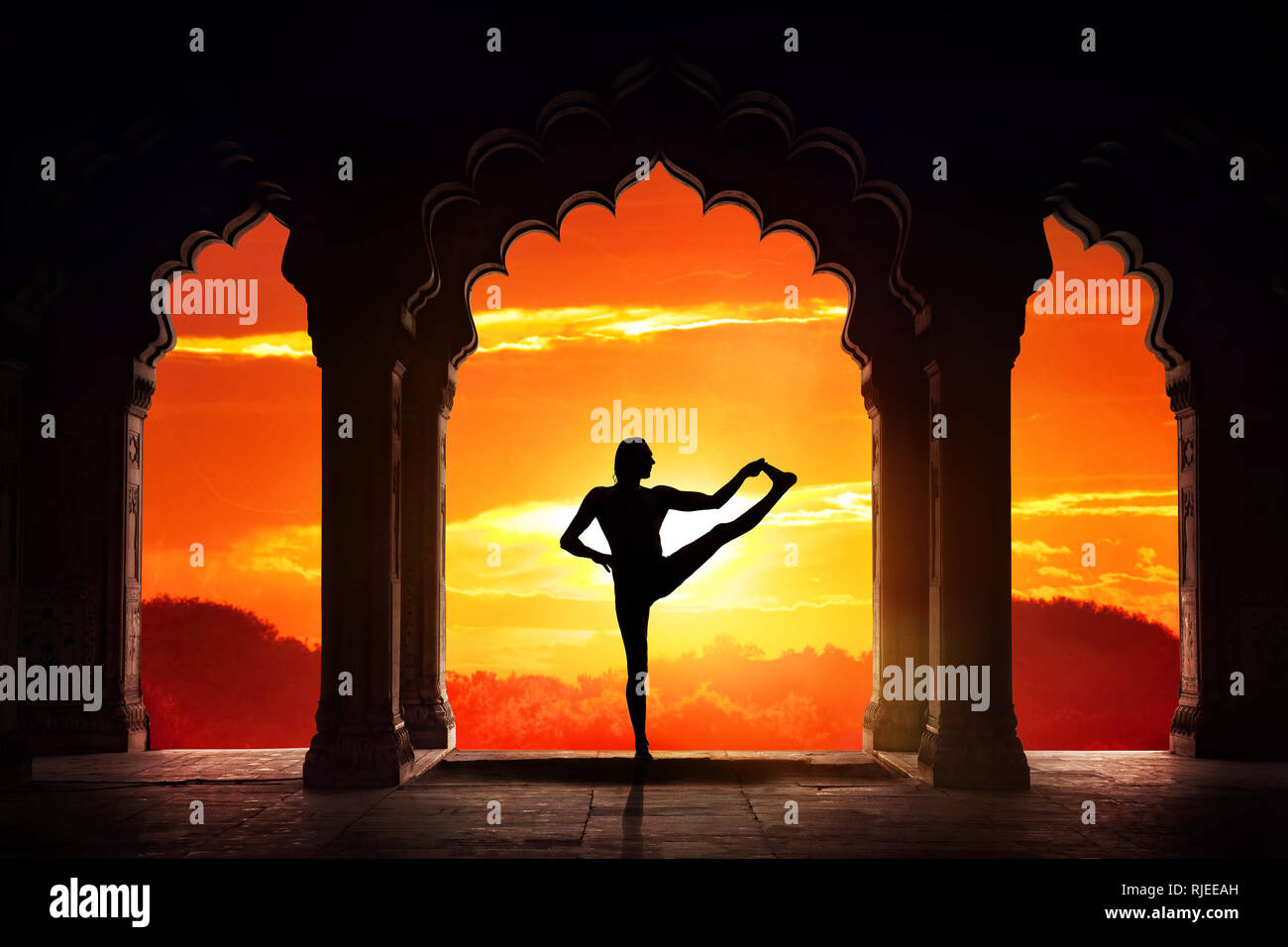 Silhouette Homme faisant du yoga équilibre avance asana dans vieux temple au fond de ciel coucher de soleil orange Banque D'Images