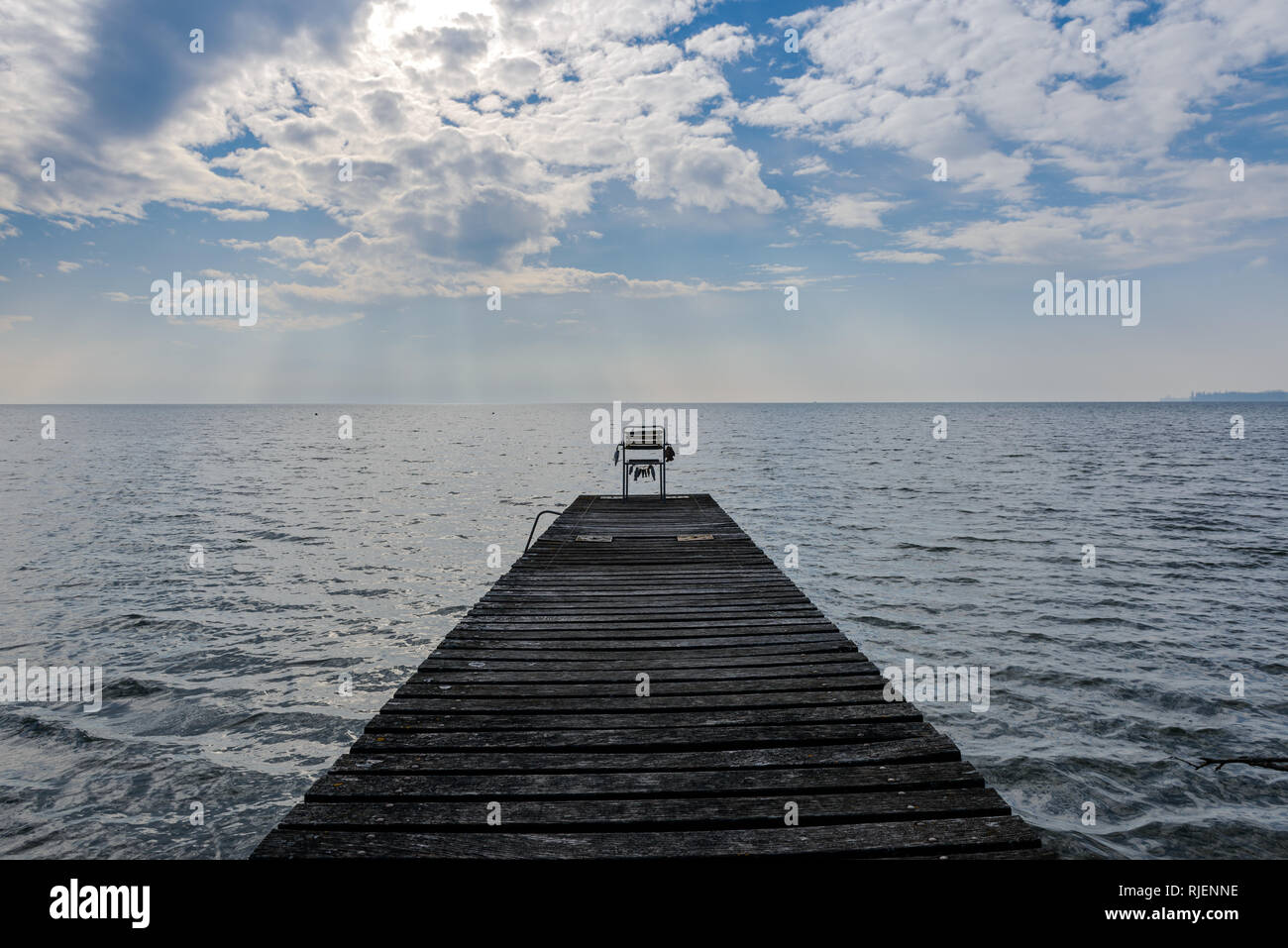 Une chaise abandonnée sur une jetée donnant sur le Lac Léman Banque D'Images