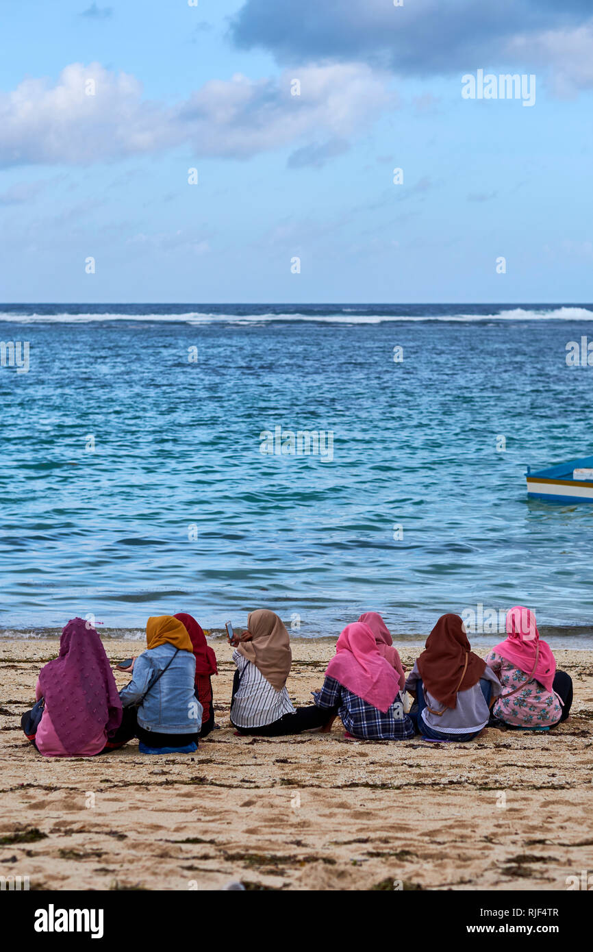 Les femmes musulmanes en foulard assis sur Pandawa Beach, Bali, Indonésie Banque D'Images