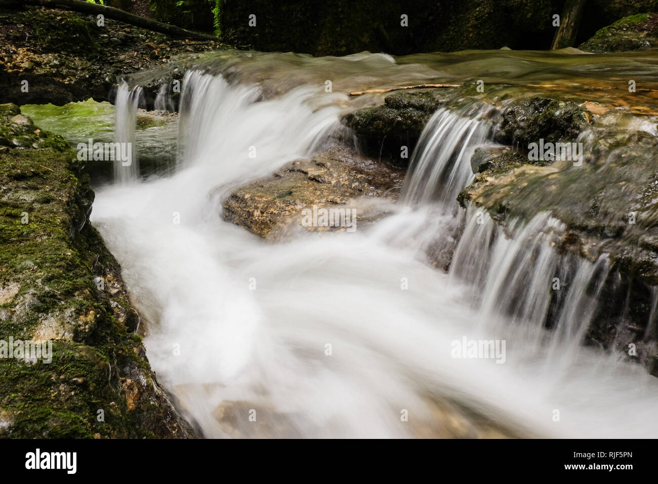 L'eau coule vers le bas d'un petit cours d'eau, long exposure Banque D'Images