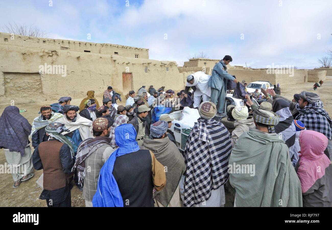 La police locale afghane de distribuer des couvertures, des écharpes et autres fournitures d'aide humanitaire comme des couvertures, des écharpes, de cuisine et d'exemplaires du Coran de villageois dans la région de Rabat Walan, province de Zabul, janv. 16. L'ALP est une attitude défensive, la force qui rassemble la sécurité et la stabilité dans les zones rurales de l'Afghanistan. Banque D'Images