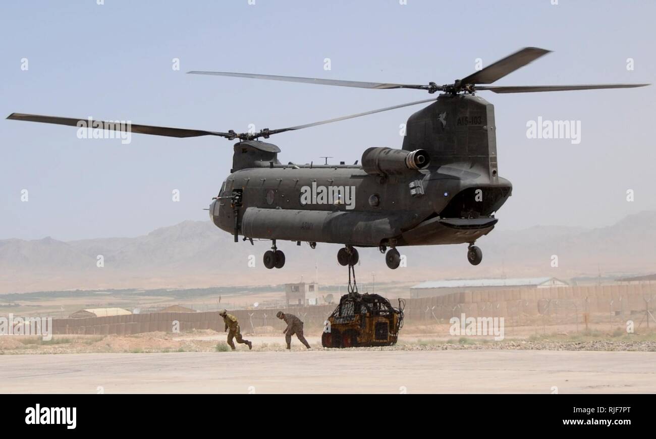 Un U.S. Navy Seabee et un aviateur australien australien s'éloigner d'un hélicoptère CH-47 Chinook de l'armée après avoir fixé un chargement de fret sur la ligne de vol à Force-Southeast d'opérations spéciales du Camp Ripley, Tarin Kowt, la province d'Uruzgan, Afghanistan, le 17 mai. L'équipement est transporté à un site plate-forme de stabilité du Village d'appuyer les projets de construction. Banque D'Images