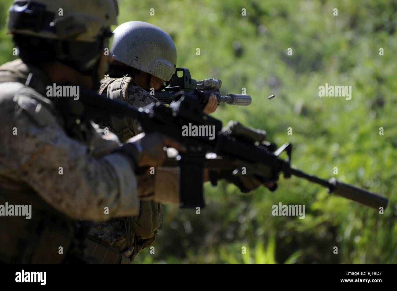 Le sergent marine. Matt Pellow de Oakland, Californie, chef d'équipe à la 4e compagnie de reconnaissance de la Force, 2e peloton, une carabine M-4 tandis que le sergent Marine. J. Sevilla de San Bernardino Comté (Californie), un adjoint Chef d'équipe a également affecté à la 4e compagnie de reconnaissance de la Force, 2e peloton, s'apprête à congédier son M-4 carbine lors d'une prise de vue réactive foret avec la gamme Kaneohe Bay Installation d'instruction le 15 août 2014. L'exercice était partie d'une formation annuelle de deux semaines période où plus de 130 4e compagnie de reconnaissance de la Force Marines menées notamment par des exercices de feu et la démolition, petit bateau oper Banque D'Images