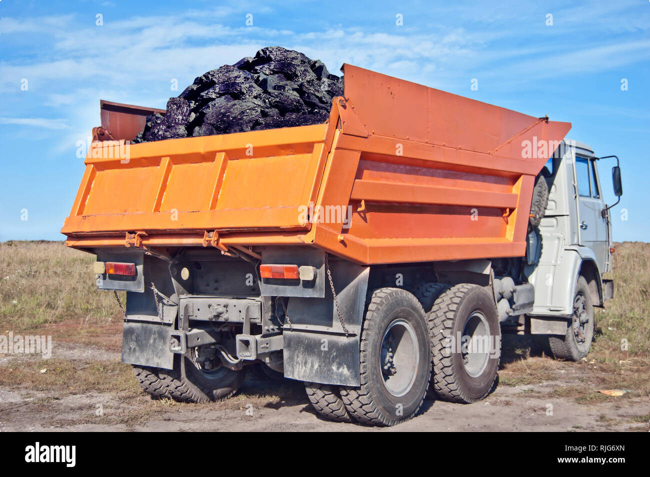 Le charbon à l'arrière du camion orange. L'extraction du charbon. Livraison de charbon Banque D'Images