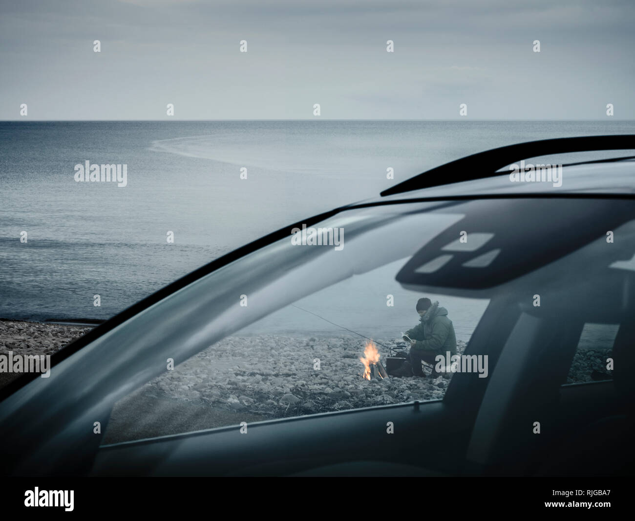 L'homme au feu de camp sur la plage Banque D'Images