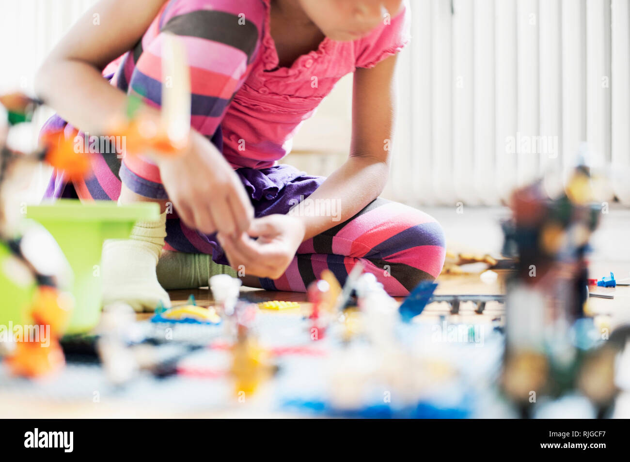 Girl Playing with toy blocks sur marbre Banque D'Images