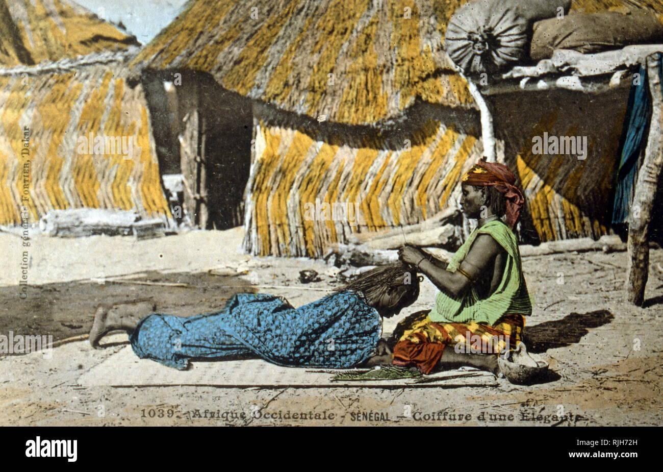 Carte postale datée de 1900, montrant deux femmes sénégalaises à tresser les cheveux avec l'un de l'autre Banque D'Images