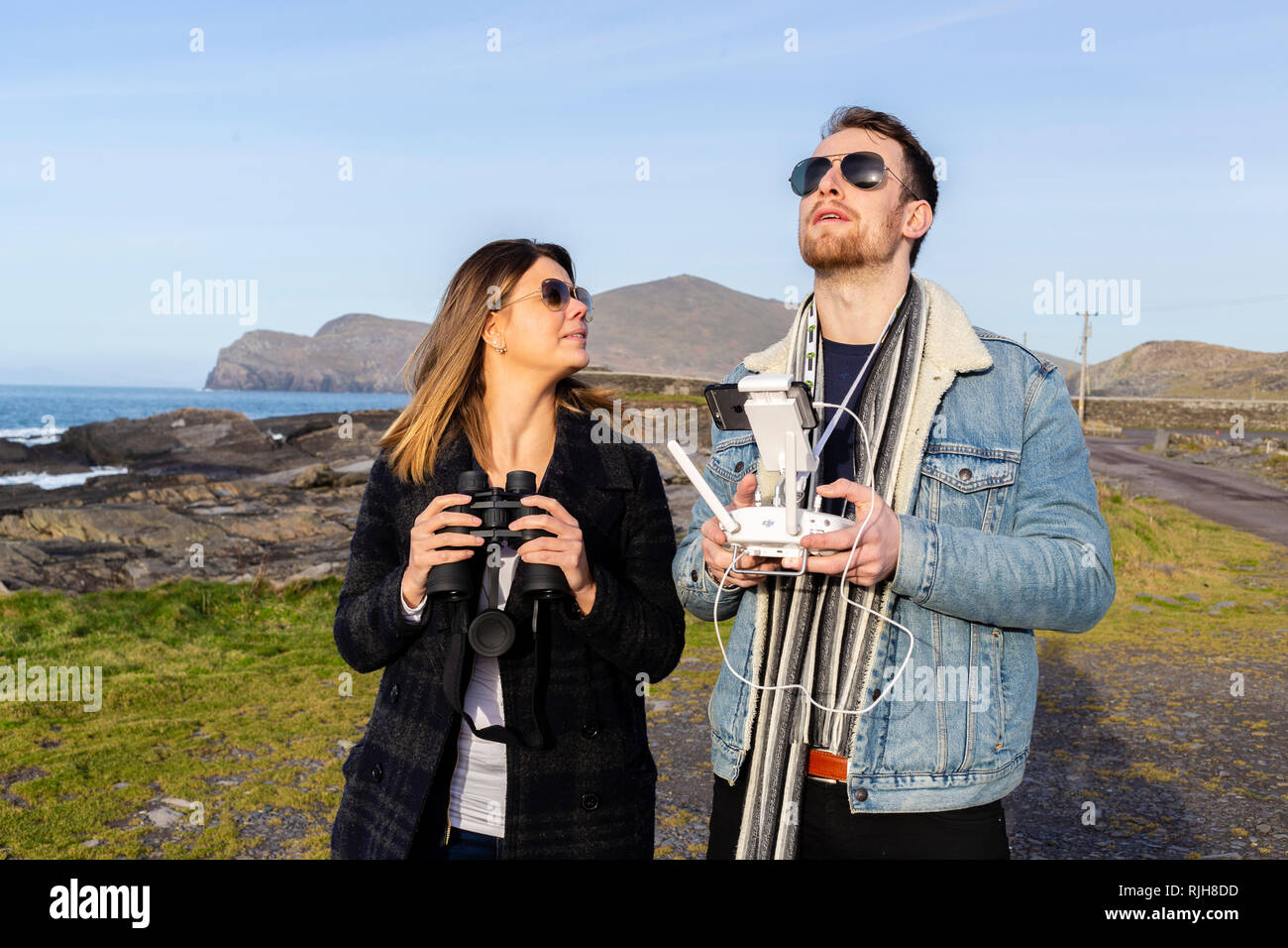 Jeune beau couple aux commandes d'un drone, Valentia Island, comté de Kerry, Irlande Banque D'Images