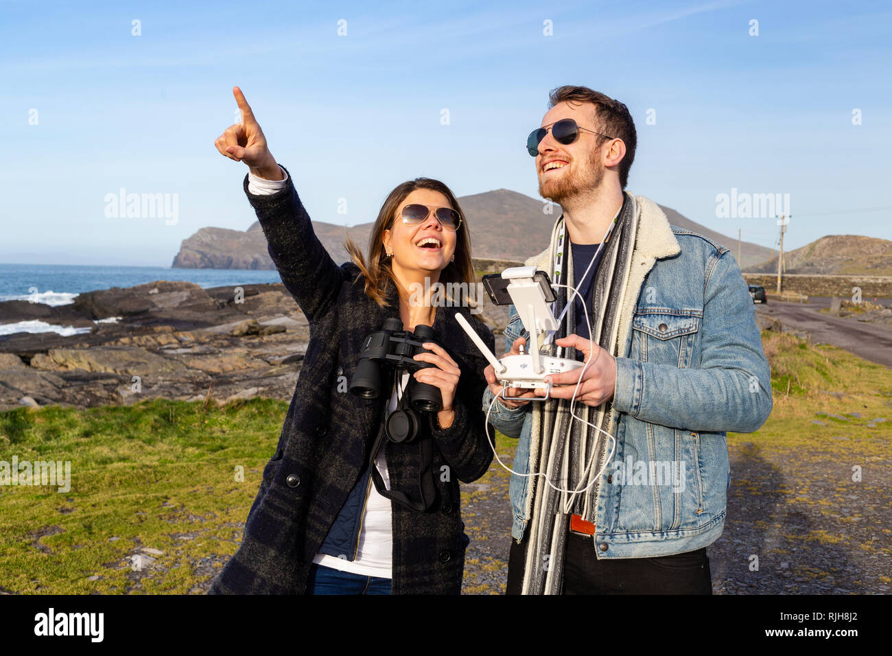Jeune beau couple aux commandes d'un drone, Valentia Island, comté de Kerry, Irlande Banque D'Images