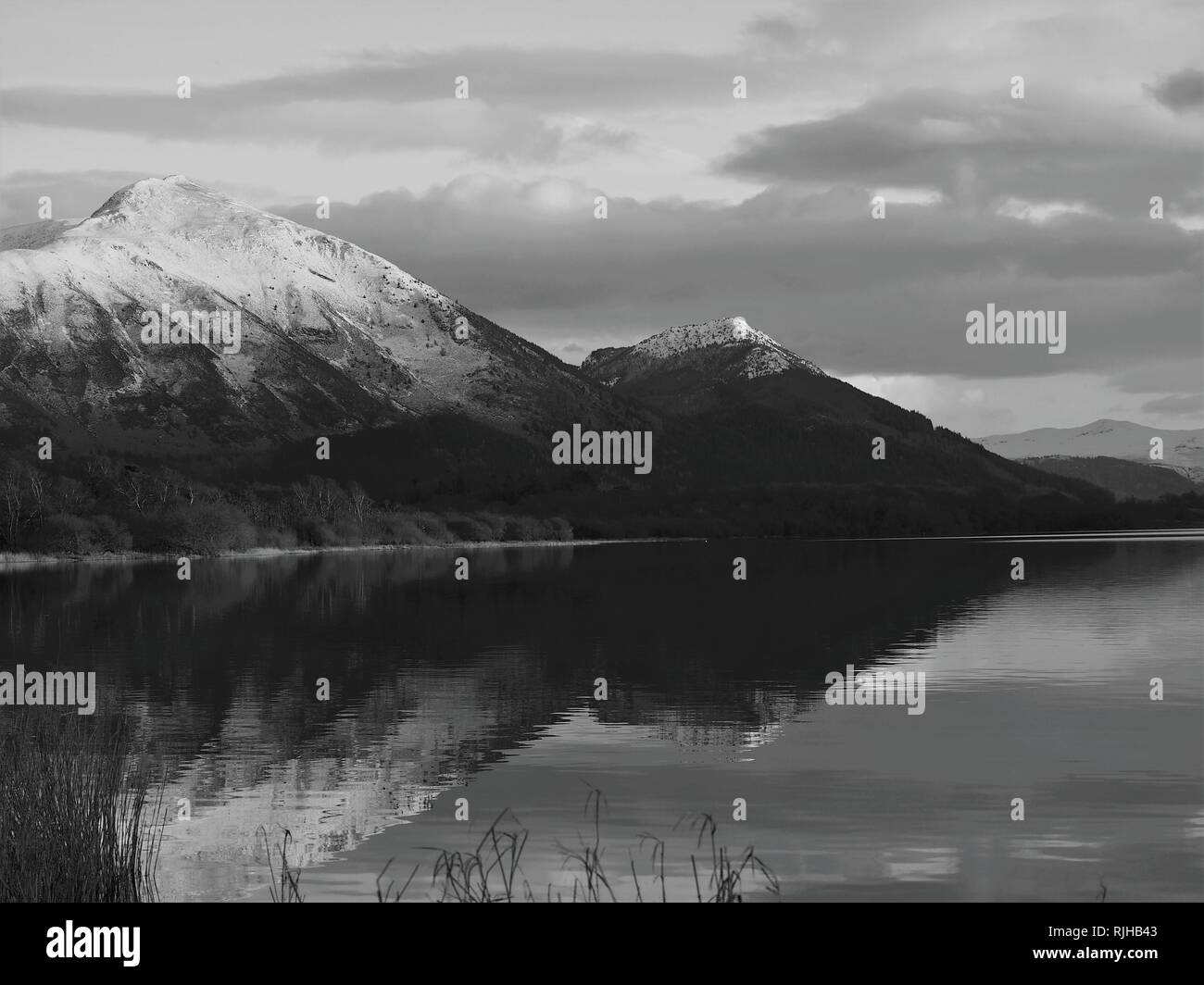 Des sommets enneigés Ullock Pike & Dodd, éclairée par le soleil qui se reflète dans le lac Bassenthwaite, Parc National de Lake District, Cumbria, Angleterre, Royaume-Uni Banque D'Images