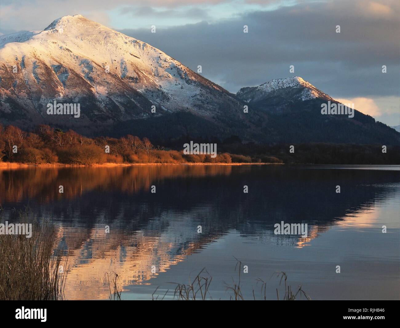 Des sommets enneigés Ullock Pike & Dodd, éclairée par le soleil qui se reflète dans le lac Bassenthwaite, Parc National de Lake District, Cumbria, Angleterre, Royaume-Uni Banque D'Images