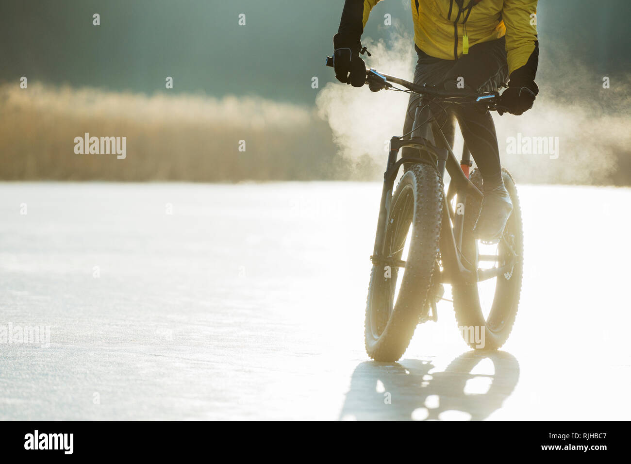 Homme randonnée à vélo sur un lac gelé Banque D'Images