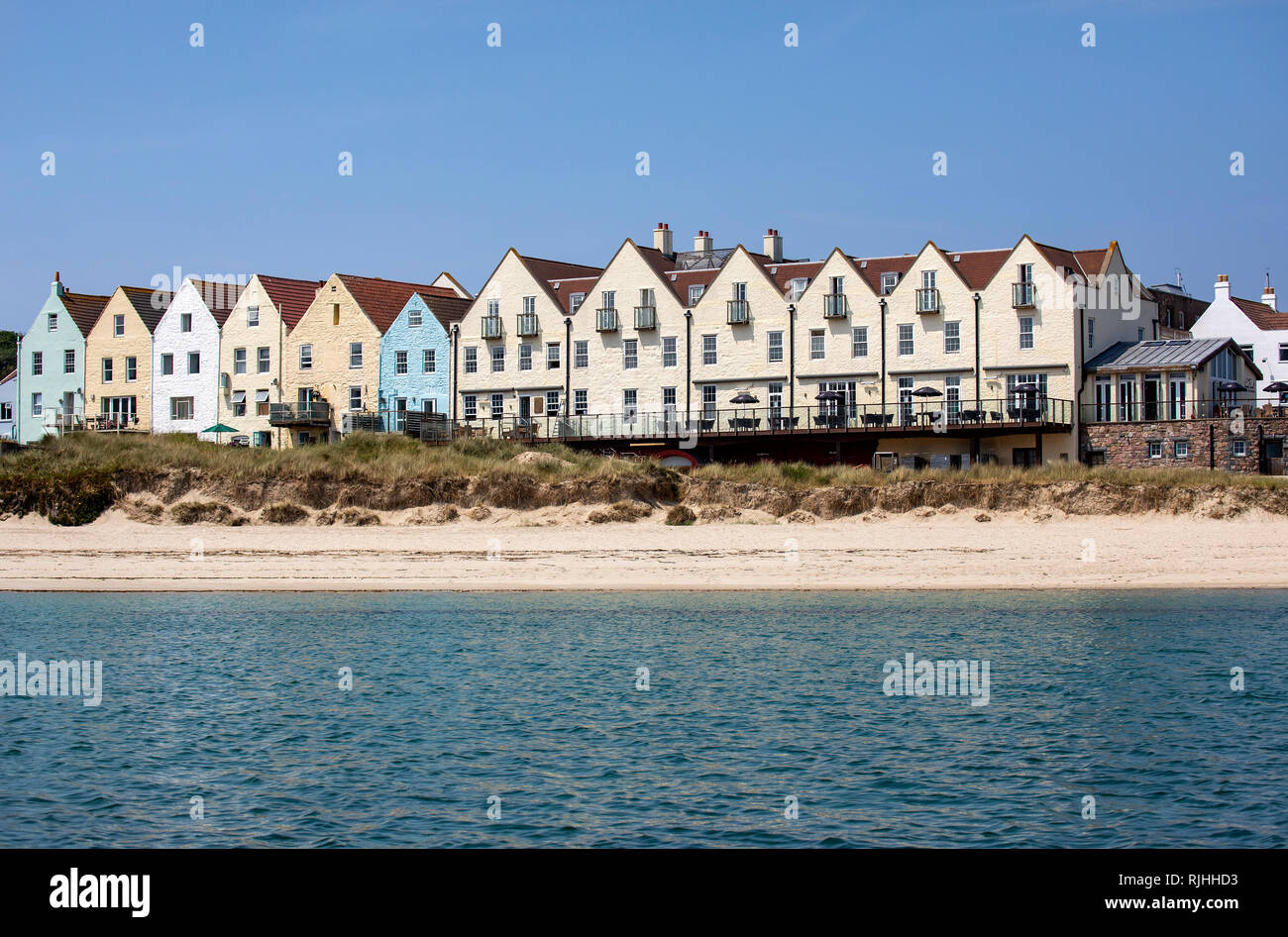 La rangée de maisons mitoyennes colorées près de Braye Harbour sur Aurigny, offrant à la fois des restaurants et d'hébergement. Banque D'Images