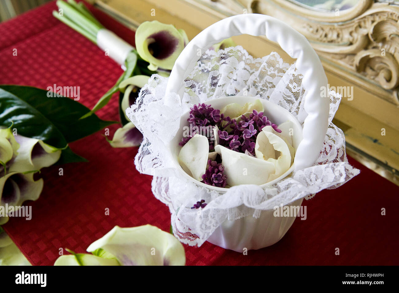 Une fleur blanche filles panier plein de fleurs violettes et blanches des pétales de rose Banque D'Images