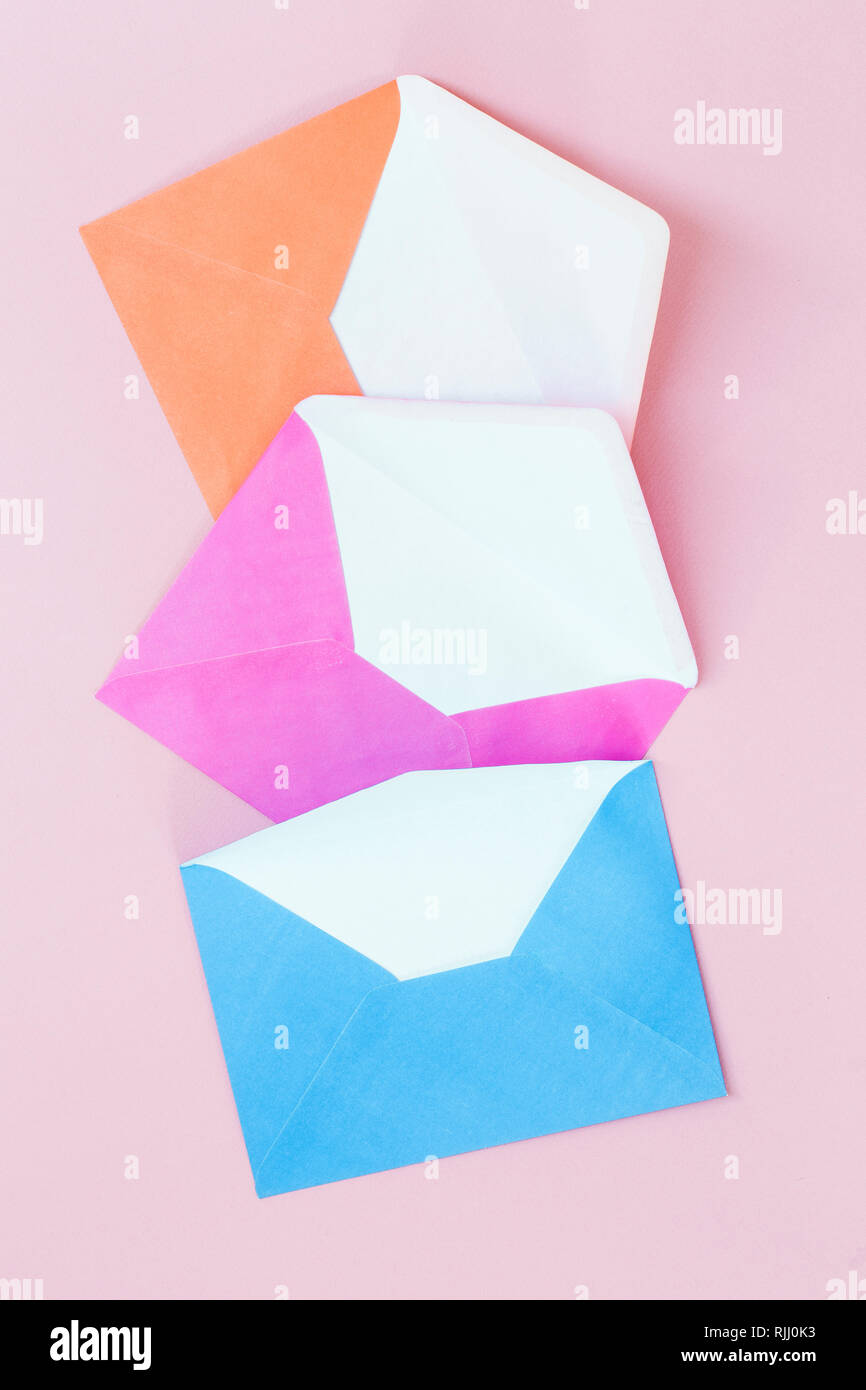 Enveloppes colorées sur fond rose Banque D'Images