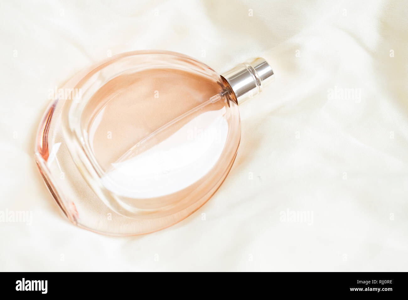 Flacon de parfum sur fond de soie Banque D'Images