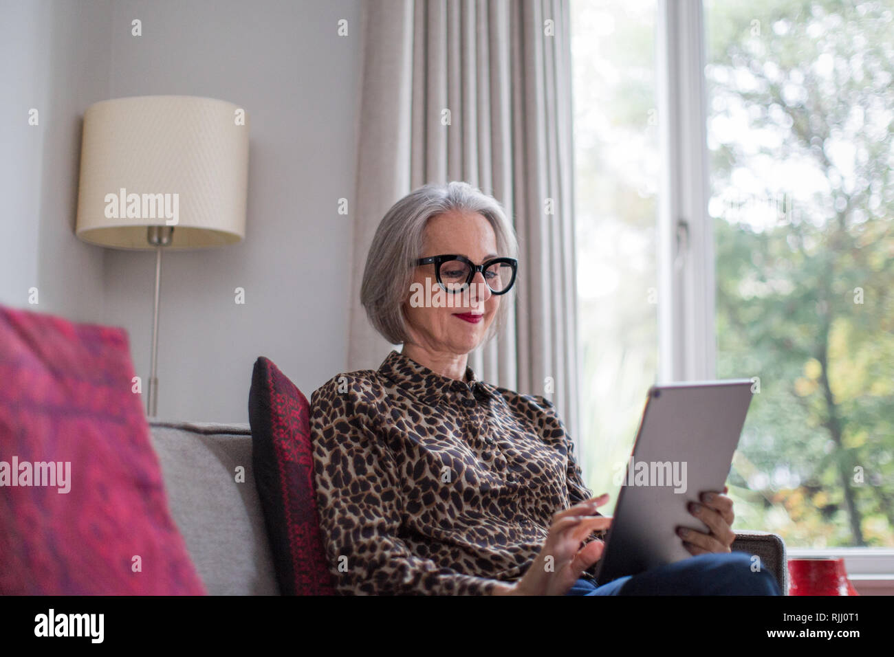 Femelle adulte mature à l'aide d'une tablette numérique Banque D'Images