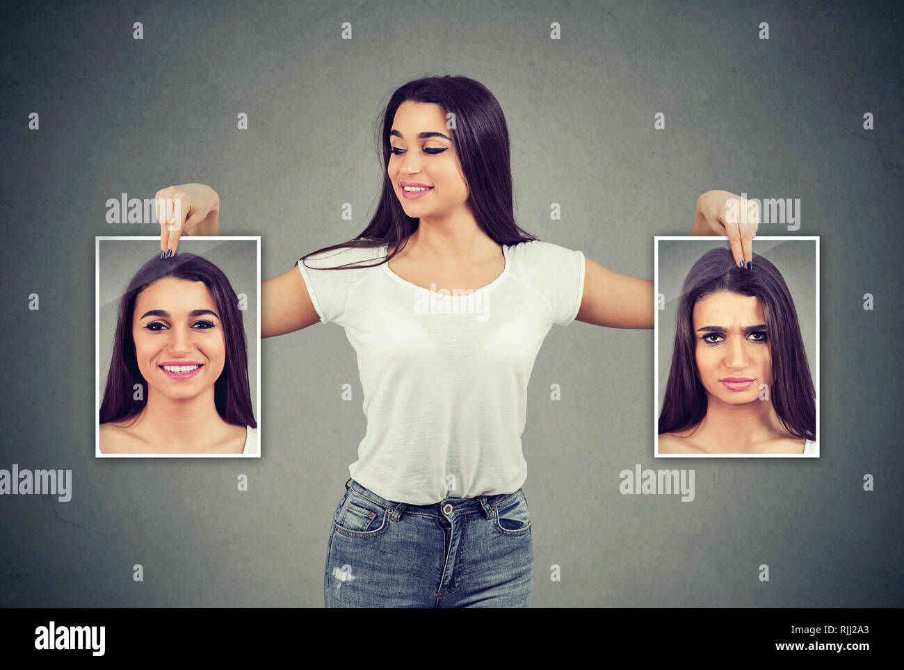 Young cheerful woman holding photos avec de bonnes et mauvaises émotions ayant de l'humeur et en souriant elle-même positive Banque D'Images