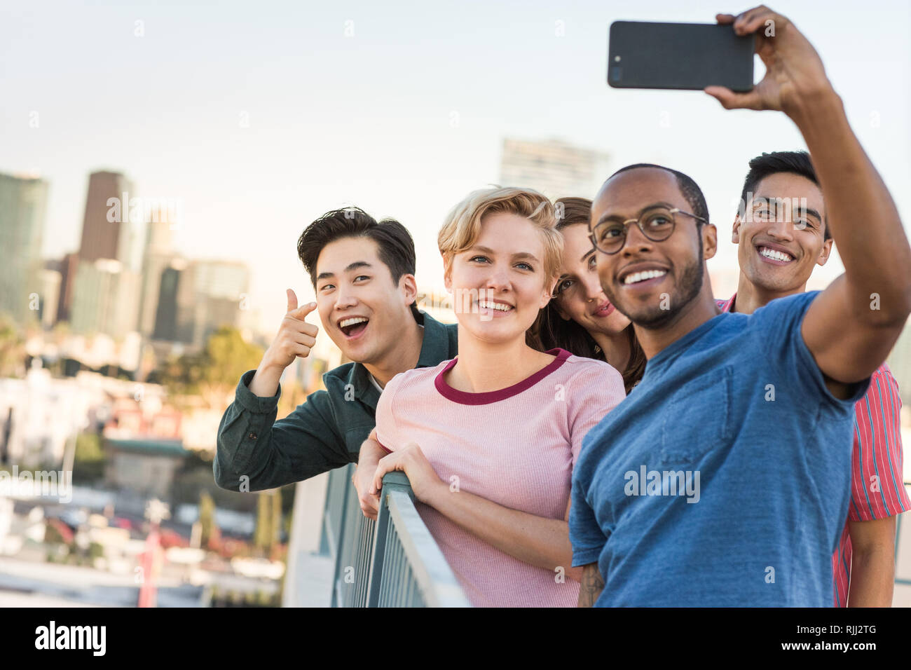 Groupe d'amis en tenant avec selfies sur les toits de la ville en arrière-plan Banque D'Images