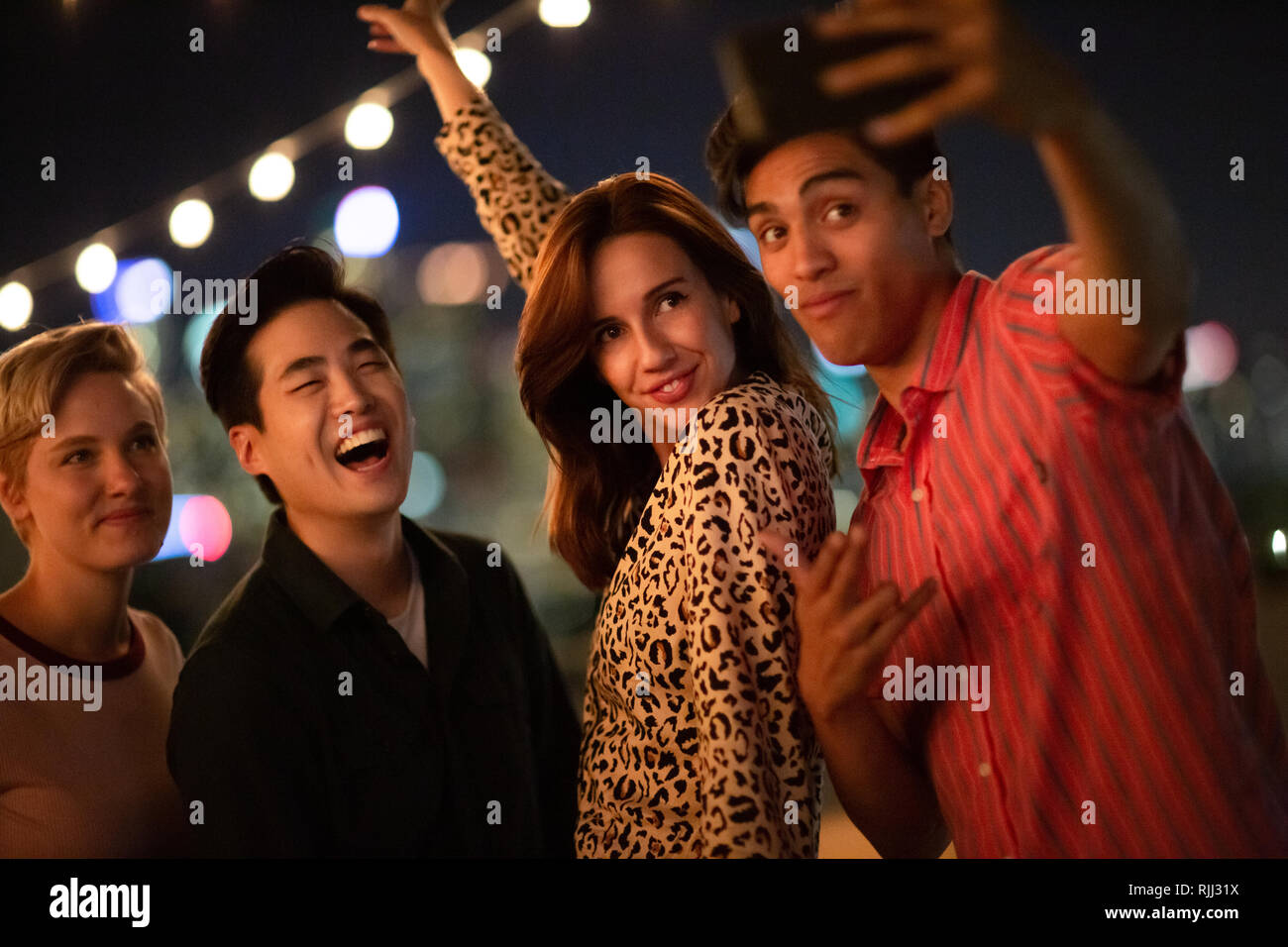 Groupe d'amis en tenant à selfies une fête en plein air la nuit Banque D'Images