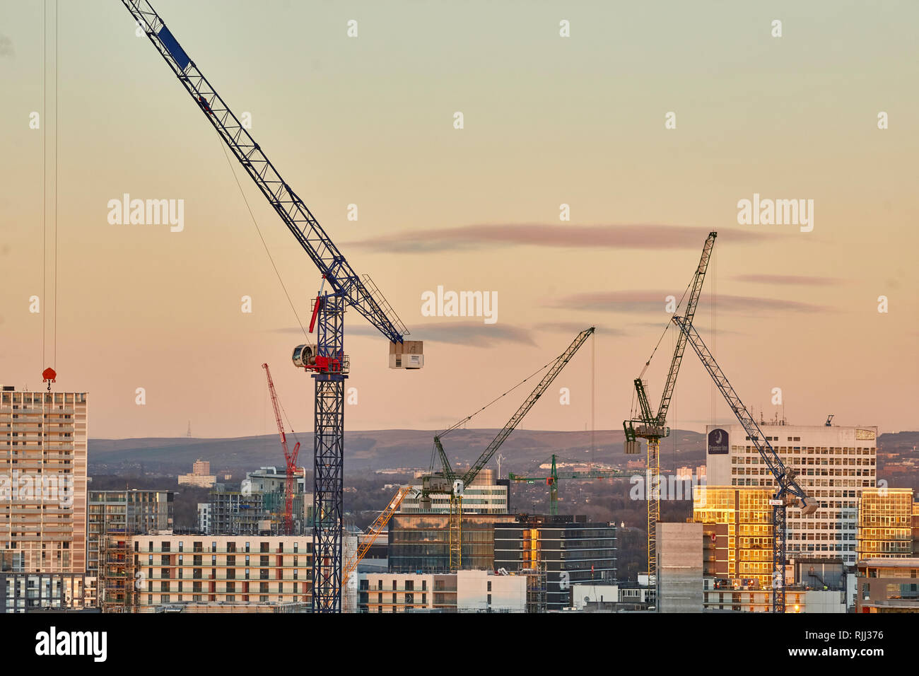 Le centre-ville de Manchester vue sur l'horizon sur les toits de Salford Crane tours dans le soir lumière Banque D'Images