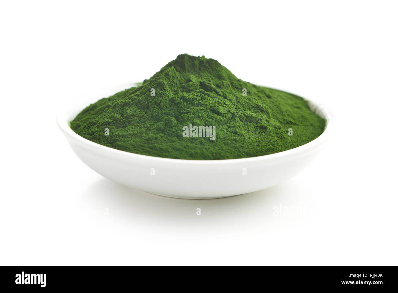La chlorelle vert ou vert en poudre dans un bol d'orge isolé sur fond blanc. Banque D'Images