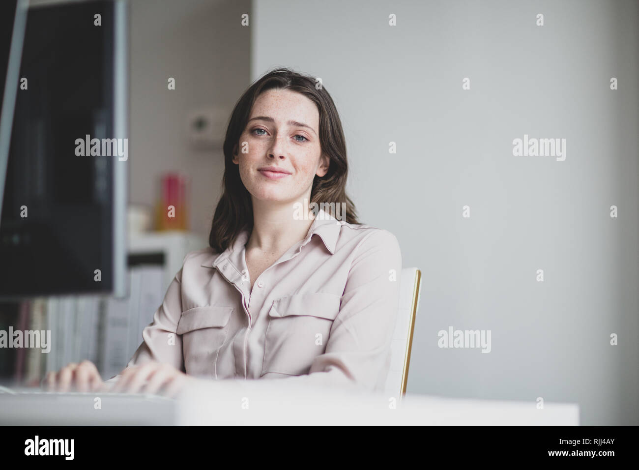 Portrait d'une femme chef d'entreprise de travailler dans un bureau sur un ordinateur de bureau Banque D'Images