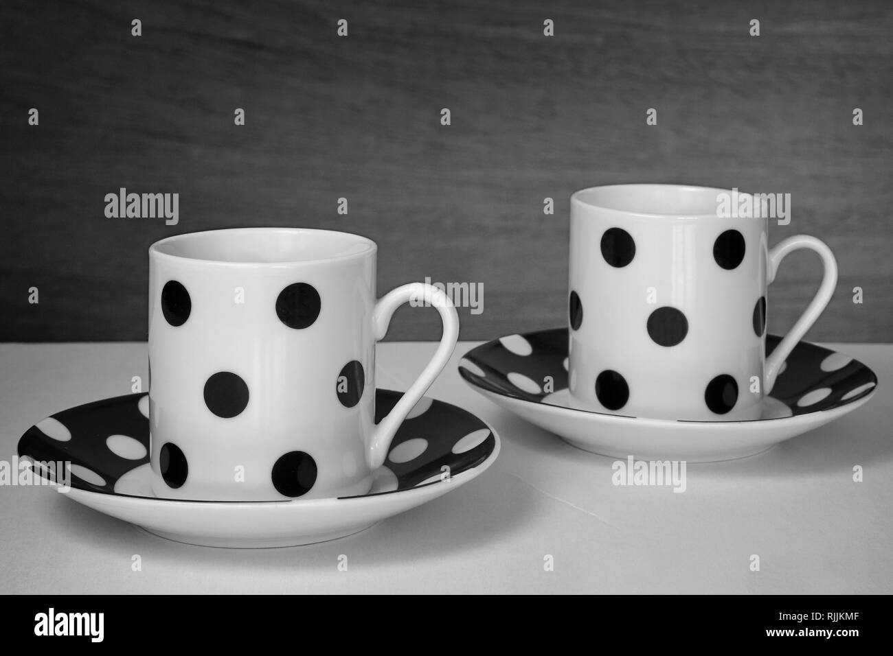 Deux tasses de café avec pois noir et le fond blanc avec son assiette Banque D'Images Deux tasses de café avec pois noir et le fond blanc avec son assiette Banque D'Images
