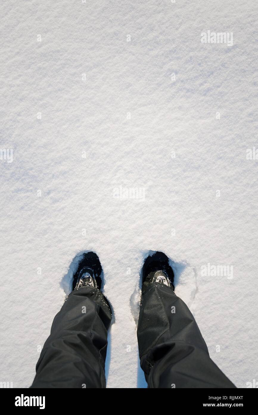 Haut télévision mise sur pieds de bottes d'hiver imperméables dans la neige fraîche, un pantalon noir, blanc copie espace arrière-plan, l'année nouvelle résolution sport concept Banque D'Images