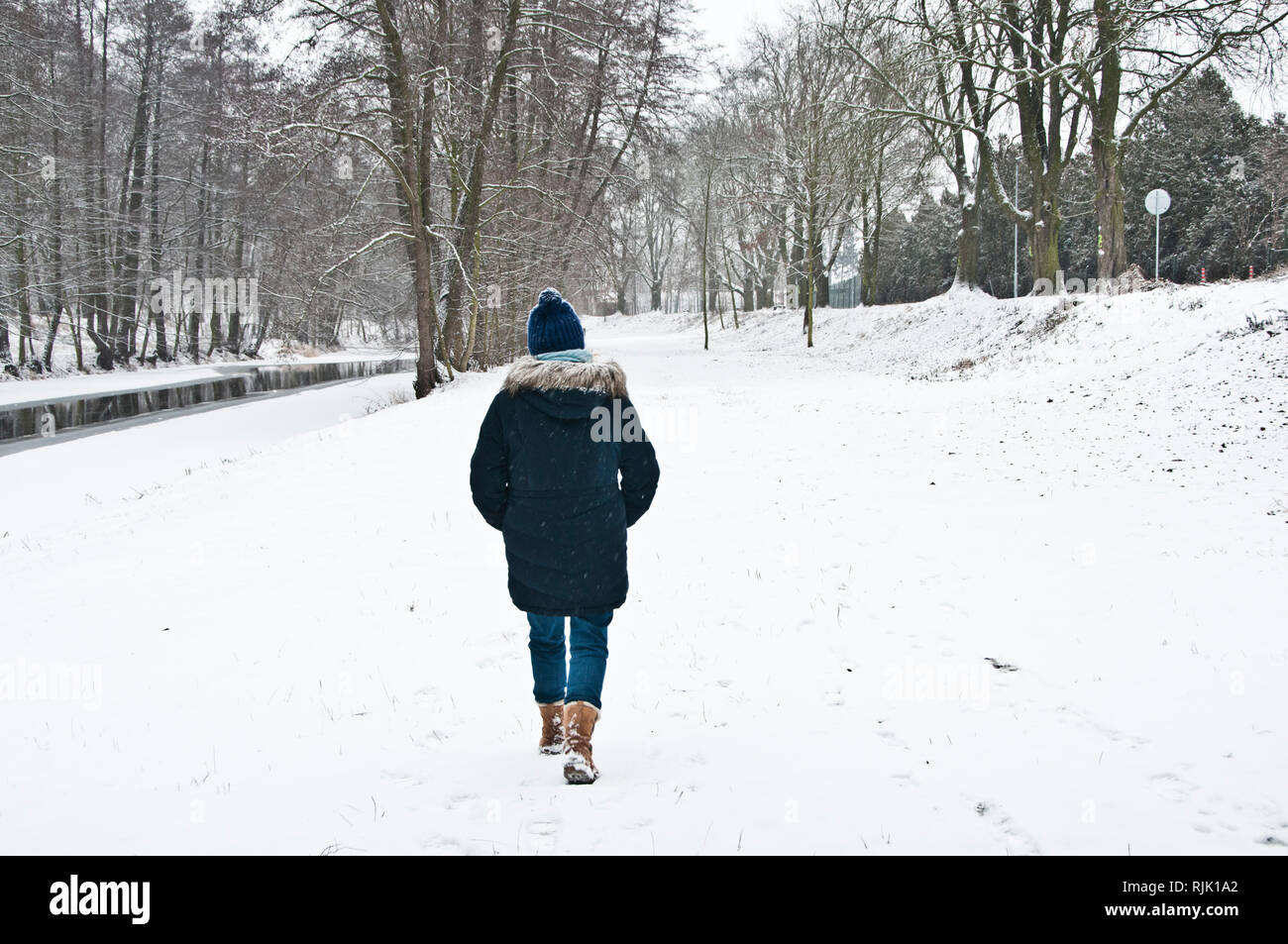 Femme de marcher seul dans les bois sous la neige Banque D'Images
