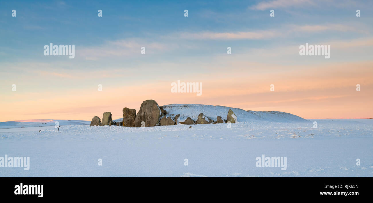 West Kennet Long Barrow dans la neige de l'hiver juste avant le lever du soleil. Chambré néolithique tombe. West Kennet, Wiltshire, Angleterre. Vue panoramique Banque D'Images